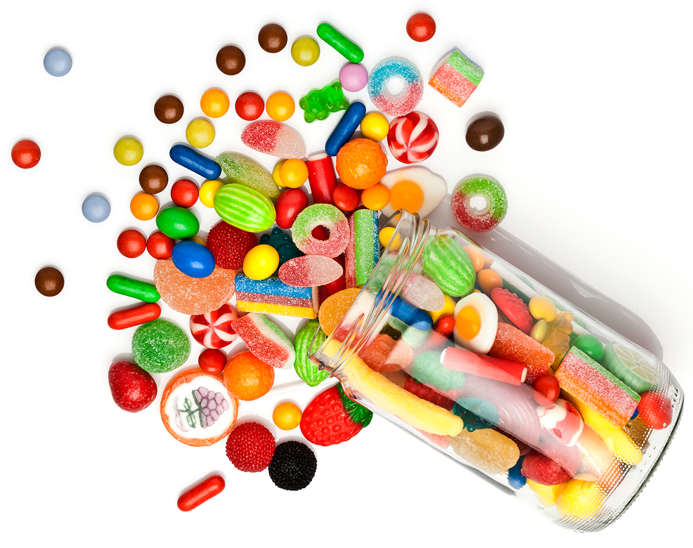 Colorful candies spilling from glass jar.