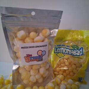 Two bags of yellow frozen fruit snacks on a white surface.