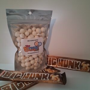 A bag of white chocolate-covered nuts and three Chunk candy bars.