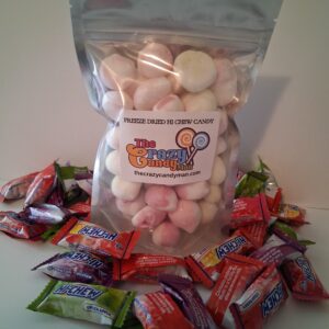 Bag of marshmallows surrounded by assorted candies.